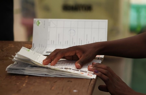 A staff worker presses ballot papers with hands at a counting station in Nairobi, Kenya, March 4, 2013. Millions of Kenyans turned up early Monday to vote in the historic general elections after independence and in the first national exercise under new constitution after the a disputed polls in 2007. According to the constitution, Kenya's Independent Electoral and Boundaries Commission (IEBC) will have seven days to officially announce the results, but the country's next president is expected to be known by Monday evening or Tuesday. (Xinhua/Meng Chenguang) 