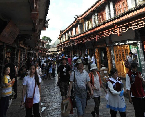 Tourists walk in the old town of Lijiang, southwest China's Yunnan Province, Aug. 8, 2012. The old town of Lijiang, a UNESCO World Heritage site with a history of more than 800 years, was formally licensed as the national 5A tourism attraction spot, the top one among China's tourism ranking system, on July 27, 2011. During the first six months of 2012, in total 8.0934 million people visited Lijiang, increasing by 55.93 percent year on year. The tourism industry's revenue of the same period reached 10.395 billion yuan ($1.634 billion), growing by 56.14 percent. Photo: Xinhua