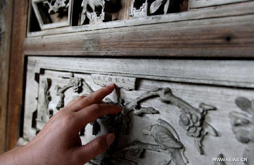 Photo taken on May 27, 2012 shows the wood carving decoration of a 200-year-old house in the Labeng stockaded village of Lianshan Village, Libo County of southwest China's Guizhou Province. Lianshan Village is an area inhabited by the Bouyei ethnic group, with the Labeng stockaded village inside it being the most well-preserved part. Some of the houses in Labeng village are over 200 years old. Libo County was listed in the world heritage sites in 2007. Photo: Xinhua