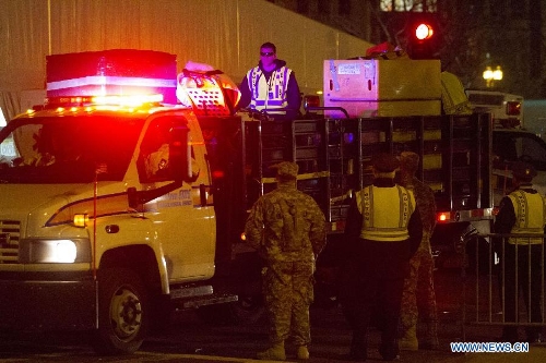 Boston EMS carries materials in front of the scene of the explosion in Boston, the United States, April 15, 2013. The two explosions that rocked the Boston Marathon on Monday has killed three people and injured at least 138, officials and media outlets said. (Xinhua/Marcus DiPaola)