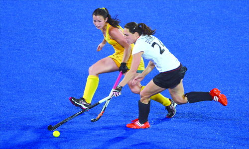 Fiona Boyce (left) of Australia attempts to tackle Maike Stoeckel of Germany during the preliminary round women's field hockey match between Germany and Australia at the Riverbank Arena in London on Tuesday. The game ended with Australia defeating Germany 3-1. Photo: AFP