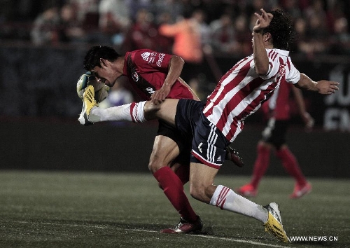 Antonio Maduena (L) of Tijuana's Xolos vies for the ball with Chivas' Hector Reynoso during a Liga MX soccer match held in Tijuana, Mexico, on May 3, 2013. (Xinhua/Guillermo Arias) 
