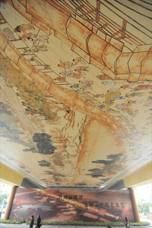 Residents crane their necks to view a replica of  a well-known ancient painting called Riverside Scene at Qingming Festival painted underneath the Hemu bridge in Hangzhou, Zhejiang Province Monday. The 30-meter-long and 10-meter-long painting completed in late November. Photo: CFP