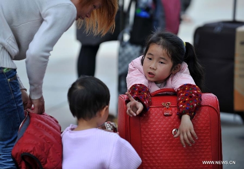  A girl talks to her younger brother at Nanning train station in Nanning, capital of south China's Guangxi Zhuang Autonomous Region, Feb. 3, 2013. Many children travel with their families during the 40-day Spring Festival travel rush which started on Jan. 26. The Spring Festival, which falls on Feb. 10 this year, is traditionally the most important holiday of the Chinese people.Public transportation is expected to accommodate about 3.41 billion travelers nationwide during the holiday, including 225 million railway passengers. (Xinhua/Zhou Hua)