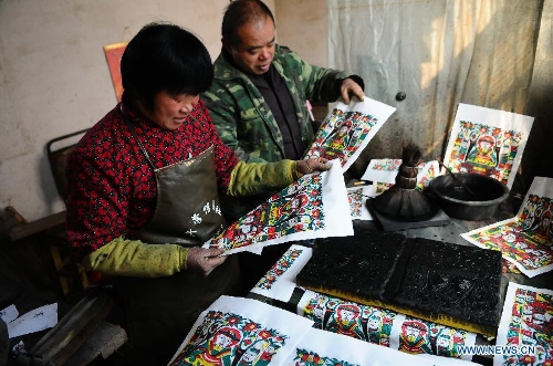 Craftsman Zhai Ruichen (R) and his wife Liu Shufang examine New Year pictures they paints in Liaocheng, east China's Shandong Province, Jan. 9, 2013. The couple were busy painting New Year pictures recently to meet the demand in local market for the Spring Festival in February. (Xinhua/Zhang Zhenxiang) 