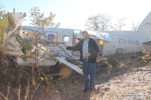 An accident investigator stands by the wreckage of a South African registered cargo aircraft that crashed on Saturday 7km northwest of the Francistown International Airport in the northeastern part of Botswana just before it landed, July 2, 2013. Botswana's Aircraft Accident Investigating Unit within the country's Ministry of Transport and Communications on Tuesday announced that investigations into last Saturday's plane crash in the northeastern part of Botswana are ongoing. (Xinhua) 