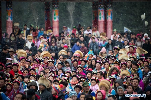 People of the Tibetan ethnic group watch the performance at the Shangjiu Festival in Baoxing County, southwest China's Sichuan Province, Feb. 18, 2013. The residents of Tibetan ethnic group in Baoxing on Monday celebrated the annual Shangjiu Festival, which means the 9th day of Chinese Lunar New Year, to express the respect to the heaven. (Xinhua/Jiang Hongjing)  