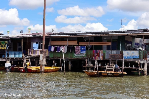 Photo taken on April 24, 2013 shows a house in the Water Village in Brunei's capital city Bandar Seri Begawan. Dubbed as Venice of the East and situated along the Brunei River, Kampong Ayer is the world's largest water village, sheltering about 30,000 inhabitants. It covers an area of 2.6 square kilo-meters and consists of 10 villages whose building are constructed on the Brunei River. (Xinhua/Li Peng) 