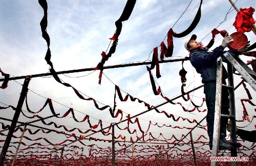  A young man hangs chains of firecrackers on a bank of the Yellow River in Zhengzhou, capital of central China's Henan Province, Feb. 3, 2005. The crackling and spluttering sound from firecrackers during the Spring Festival or Chinese Lunar New Year is expected to intimidate the Nian, a beast in Chinese mythology which comes out of hiding to attack people around Chinese New Year. Chinese people who live in the central China region have formed various traditions to celebrate the Chinese Lunar New Year. (Xinhua/Wang Song)  