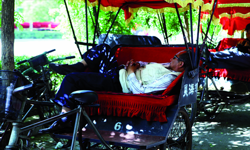 Main: a moment in the shade. It is no surprise that this man is exhausted after cycling people around in the heat. 
Left: this animal is not monkeying around, but instead totally knackered.
Above: with many places still without air conditioning, Beijing's subways are some of the best places to cool down. 
Photos: Guo Yinggguang/GT and CFP  1