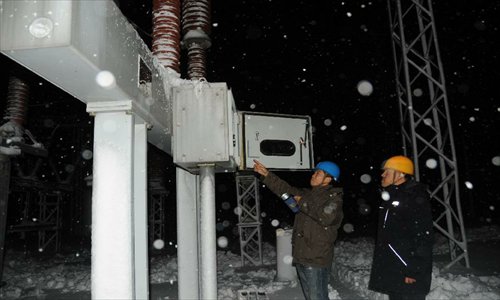 Working staff check power equipments at the Hegang Power Bureau in Hegang, northeast China's Heilongjiang Province, November 13, 2012. Heavy snowstorms have cut off regional power and water supplies as well as forced schools and highways to close in northeast China's Heilongjiang and Jilin provinces on Monday. Photo: Xinhua