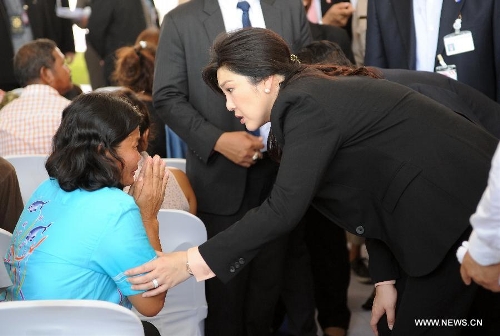 Thai Prime Minister Yingluck Shinawatra talks to a relative of an unshackled prisoner at Central Bangkwang Prison in Nonthaburi Province, Thailand, on May 15, 2013. More than 500 prisoners who committed serious crimes have had the handcuffs and foot shackles removed in Thailand. (Xinhua/Gao Jianjun) 