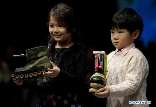 Two young models present entries of the 13th Hong Kong Footwear Design Competition during the awarding ceremony of the event in south China's Hong Kong, Jan. 15, 2013. The ceremony is held on the second day of the Hong Kong Fashion Week for Fall/Winter, which lasts from Jan. 14 to Jan. 17 at Hong Kong Convention and Exhibition Centre. (Xinhua/Lui Siu Wai) 