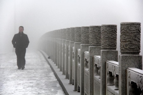 A pedestrian walks in fog in Bazhou City, north China's Hebei Province, Jan. 22, 2013. (Xinhua/Wang Geming) 