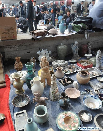 Curios are seen at a flea market in Zhengzhou, capital of central China's Henan Province, April 14, 2012. The flea market of Zhengzhou Antique Market attracted many collectors everyday. Venders lay their goods on the ground, making the flea market a popular place for curios and antiques business. Photo: Xinhua