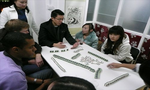 Westerners watch and learn how to make dumplings and the skills and tactics of playing mahjong. Photos: Global Times