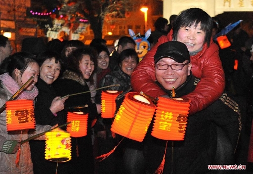  People carry lanterns during the 29th day of the 12th lunar month at a plaza in Zhengzhou, capital of central China's Henan Province, Feb. 1, 2011. It is a custom for people living in the central China region to carry lanterns on the 29th day of the 12th lunar month outdoors to pray for good luck. Chinese people who live in the central China region have formed various traditions to celebrate the Chinese Lunar New Year. (Xinhua/Wang Song)