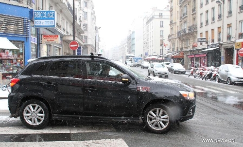 Photo taken on March 12, 2013 shows cars running in snow on the street of Paris, capital of France. According to Meteo France, the country's weather agency, two departments were put under red alert and 27 others including Paris and suburbs under orange alert on predicted heavy snowfall till Wedenesday morning. (Xinhua/Zheng Bin)