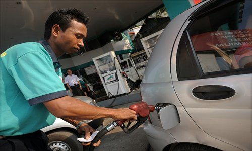 A Myanmar worker fills up a car at a gas station in Yangon on Saturday. While other countries may be more reliable and better equipped, Myanmar has emerged as the new promised land of exploration for global oil and gas giants unperturbed by a lack of data on its proven energy reserves. Photo: AFP  