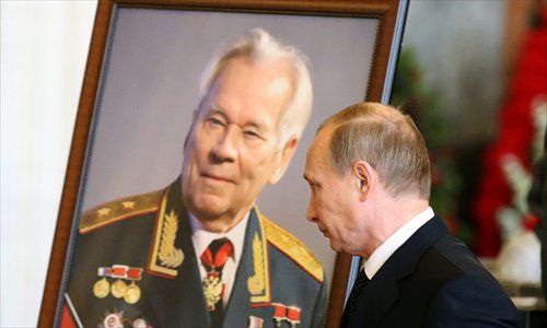 Russian President Vladimir Putin walks past a portrait of Mikhail Kalashnikov, the designer of the iconic AK-47 assault rifle that was the favored weapon of guerrillas worldwide, during his funeral ceremony in Moscow on Friday. Kalashnikov, who died on Monday at the age of 94, was to receive a funeral with full state honors and be buried at the Federal Military Memorial Cemetery in Mytishchi outside Moscow, the defense ministry said. Photo: AFP