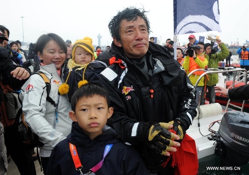 China's Guo Chuan (R Front) walks with his family after returning home in Qingdao, east China's Shandong Province, April 5, 2013. Guo sailed back home on Friday morning to become the first Chinese to successfully circumnavigate the globe singlehanded. Aboard his Class40 yacht, 48-year-old Guo travelled about 21,600 nautical miles in 138 days before he returned to his hometown of Qingdao, where he set off on November 18 last year. (Xinhua/Li Ziheng)