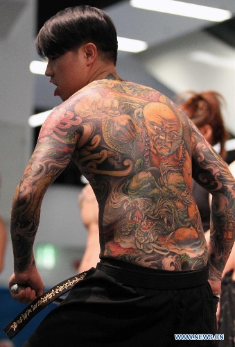 A man from Asia shows his tattoo during the 21st International Tattoo Convention in Frankfurt, Germany, March 22, 2013. The Tattoo Convention kicked off on Friday and will last for three days. (Xinhua/Luo Huanhuan)