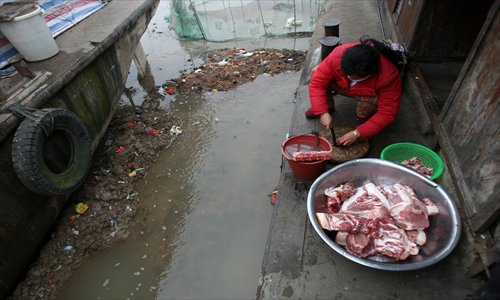 A woman prepares Spring Festival meal on the deck of her family's marooned houseboat.Photo: CFP