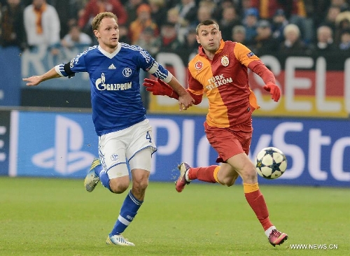 Benedikt Hoewedes (L) of FC Schalke 04 vies with Burak Yilmaz of Galatasaray during the UEFA Champions League eighth-final match at Veltins Arena in Gelsenkirchen, west Germany, March 12, 2013. Galatasaray won 3-2 and entered the quarterfinal. (Xinhua/Ma Ning) 