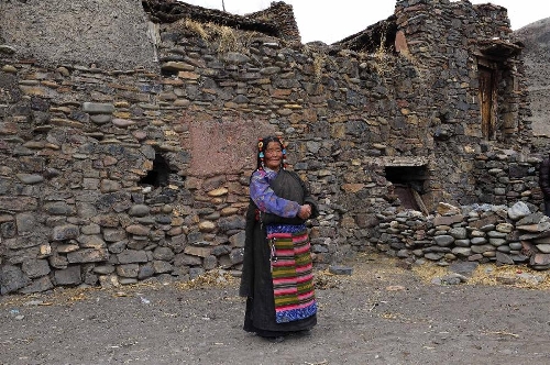 The 65-year-old Haji poses for photos in front of her stone house which is aged over 600 years in Yangda Village of Riwar Township in Suoxian County in the Nagqu Prefecture, southwest China's Tibet Autonomous Region. Three stone houses, each with the age exceeding more than 600 years, are preserved well in the village. (Xinhua/Liu Kun)  