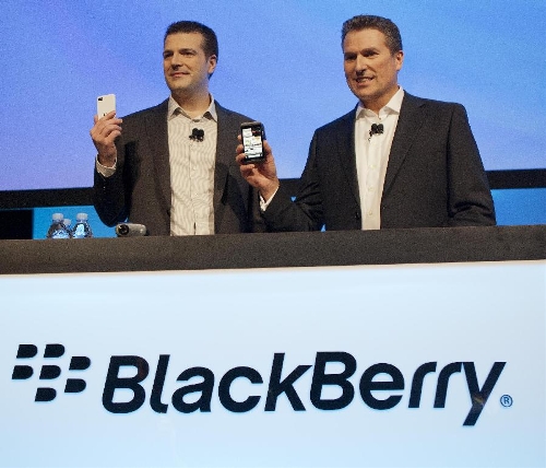 Managing Director for Canada of RIM Andrew MacLeod (L) and Chief Financial Officer Brian Bidulka show new smartphone Z10 behind a desk with company's new logo at a press event in Toronto, Canada, Jan. 30, 2013. Canadian telecommunication and wireless equipment company Research In Motion Ltd. (RIM) announced to rename its name to BlackBerry on Wednesday. (Xinhua/Zou Zheng) 