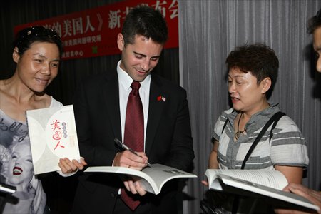 Devon Nixon (center) autographs the book at the book launch event. Photo: Courtesy of Ye Jun