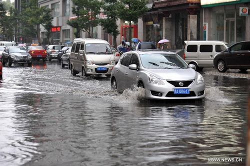 Motorcars run on a flooded road in Taiyuan, capital of North China's Shanxi Province, July 31, 2012. A downpour hit the city on Tuesday morning and caused urban waterlogging. Photo: Xinhua
