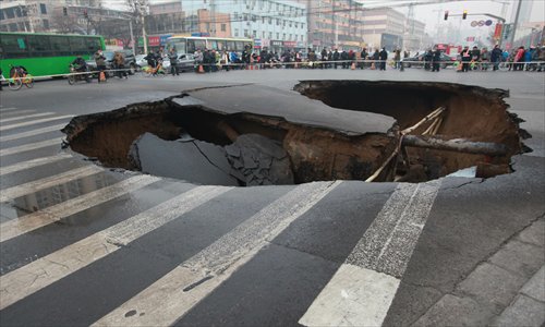 People gawk at a 10-meter-wide sinkhole at an intersection in Taiyuan, Shanxi Province. The road sink appeared on Wednesday afternoon and claimed no casualties.  Photo: CFP