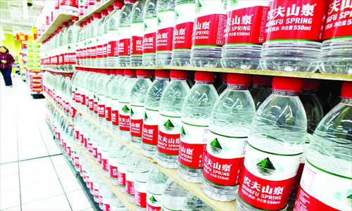 Bottles of Nongfu Spring water line shelves in a supermarket in Yichang, Central China's Hubei Province Tuesday. The International Finance News reported Tuesday that the mineral water producer was recently found using a quality standard from East China's Zhejiang Province for its products made and sold in South China's Guangdong Province. The standard allows higher levels of fungi and yeasts, and Nongfu's practice may have violated Guangdong food safety regulations, the newspaper reported. Photo: CFP