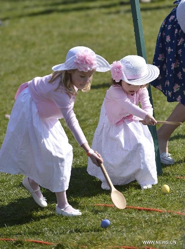 Two young sisters participate in the annual White House Easter Egg Roll on the South Lawn of the White House in Washington D.C., capital of the United States, April 1, 2013. U.S. President Barack Obama hosted the annual celebration of Easter on Monday, featuring Easter egg roll, live music, sports, cooking and storytelling. (Xinhua/Zhang Jun) 