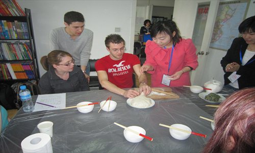 Westerners watch and learn how to make dumplings and the skills and tactics of playing mahjong. Photos: Global Times