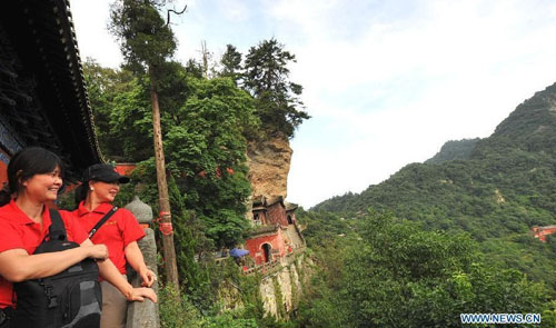 Visitors enjoy the sightseeing of the Wudang Mountain in central China's Hubei Province July 11, 2012. As the cradle of the Taoist culture, the Wudang Mountain was inscribed on the list of World Cultural Heritages in 1994. The scenery of the mountain attracts tens of thousands of visitors every year. Over 4 million tourists from at home and abroad are expected to visit the site this year. Photo: Xinhua