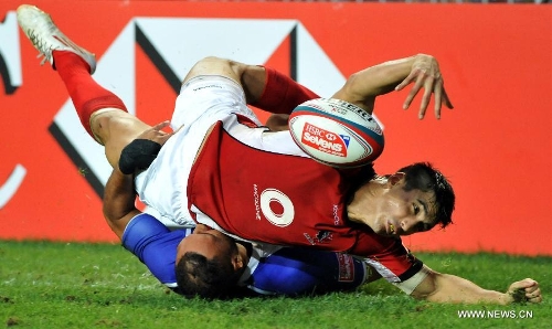 Sean Dukem (top) of Canada vies with Lolo Lui of Samoa during a match at the Hong Kong Sevens rugby tournament in south China's Hong Kong, March 24, 2013. Samoa won the match 12-7 to win the 5th place. (Xinhua/Lo Ping Fai) 