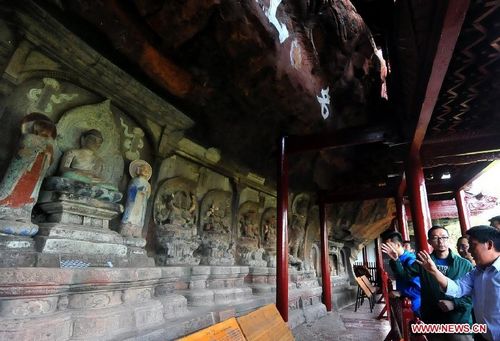 Tourists visit a grotto sculpture in the Shibao Mountain of Jianchuan County in Dali Bai Autonomous Prefecture, Southwest China's Yunnan Province, August 9, 2012. A wide range of subject matters are featured in the grottos, including political life of the Nanzhao Dynasty (738-902), Buddhist figures and religious beliefs of the Kingdom of Dali. The grottos here were listed into the first batch of China's historic and cultural sites in 1961. A total of 16 grottos and 139 sculptures were open to the public so far. Photo: Xinhua