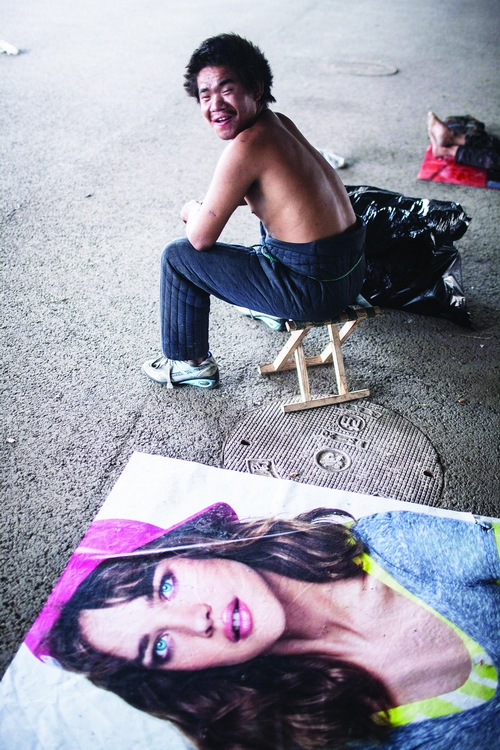 A homeless man, who lives on collecting plastic bottles and selling them to garbage recycling stations, sits under Guomao Bridge, Chaoyang district, Thursday. The government launched a campaign to provide shelter to the homeless, in a bid to create a favorable city environment. Photo: Li Hao/GT