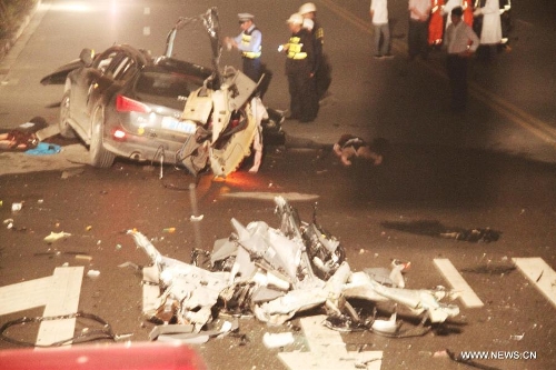 Rescuers work at the accident site after a car with eight passengers collided with a trailer in Wenzhou City, east China's Zhejiang Province, May 12, 2013. Seven people were killed and one other injured in the accident, which ocurred at midnight on Saturday. (Xinhua)