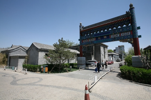 A decorated archway under renovation(Photo: CRIENGLISH.com/ Wang Zhi)A Hutong is a traditional alley, characteristic of an old Beijing city. A total of 7000 Hutongs have been built throughout the capital in straight lines under strict construction guildlines. The longest Hutong starts from the Beijing Legation Quarter, Dong Jiao Min Xiang,to the Xijiao Min Xiang, and has a total length of 6.5 kilometers, while the shortest Hutong is One-inch Street at only several meters' long. The narrowest Hutong is only about 0.7 meters wide. Therefore, people carrying even a little bit of extra weight have to hold their breath to pass through it. Formed during the Yuan, Ming and Qing, dynasties thousands of Hutongs surround the supreme Imperial Palace from all directions. They are woven into the fabric of people's daily lives.