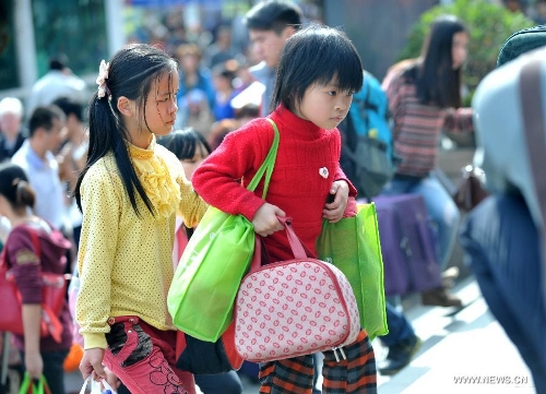 Two girls carrying luggage enter the Nanning train station in Nanning, capital of south China's Guangxi Zhuang Autonomous Region, Feb. 3, 2013. Many children travel with their families during the 40-day Spring Festival travel rush which started on Jan. 26. The Spring Festival, which falls on Feb. 10 this year, is traditionally the most important holiday of the Chinese people.Public transportation is expected to accommodate about 3.41 billion travelers nationwide during the holiday, including 225 million railway passengers. (Xinhua/Zhou Hua)