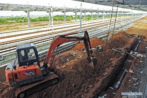  Photo taken on Oct. 21, 2011 shows an excavator working in the completing Shangyu railway station of the Hangzhou-Ningbo high-speed railway in Shangyu, east China's Zhejiang Province. Designed at a top speed of 350km/h, the 150-kilometer Hangzhou-Ningbo high-speed railway linking Hangzhou and Ningbo, two hub cities in Zhejiang, will reduce the travel time to 36 minitues when it is put into operation in July 2013, as expected. (Xinhua/Tan Jin)  