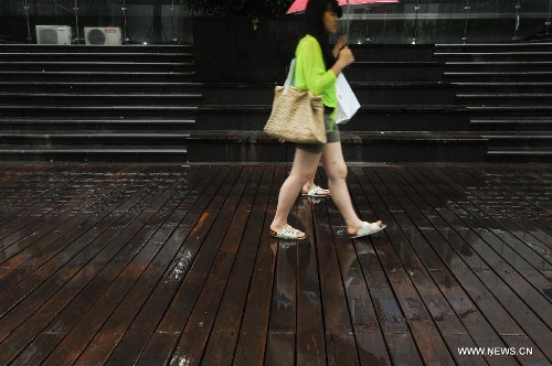 Pedestrians walk amid rain in Shenzhen, south China's Guangdong Province, May 26, 2013. Torrential rain hit most parts of Guangdong Province from Saturday to Sunday. (Xinhua/Mao Siqian)  