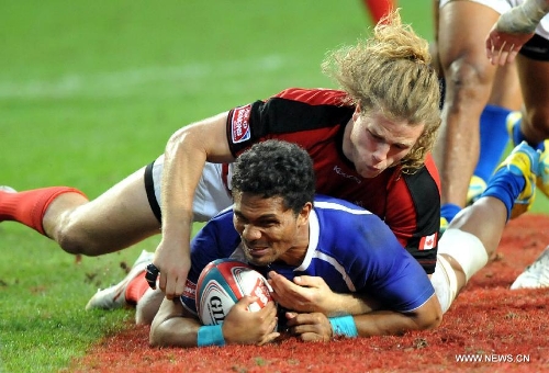 Conor Trainor (top) of Canada vies with Afa Aiono of Samoa during a match at the Hong Kong Sevens rugby tournament in south China's Hong Kong, March 24, 2013. Samoa won the match 12-7 to win the 5th place. (Xinhua/Lo Ping Fai) 