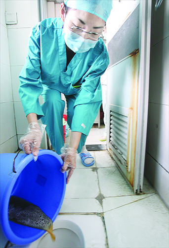 Yang disposes of waste during her one-day experience at a Wuhan Hospital. Photo: IC