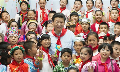 Chinese President Xi Jinping (C) poses for group photo with children during a children's activity in Beijing, capital of China, May 29, 2013. Photo: Xinhua