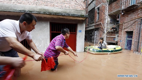 People rescue a trapped villager on waterlogged road at Shaoyun Township in Tongliang County of Chongqing, southwest China, July 1, 2013. Rainstorm-triggered natural disasters have hit nine provincial-level regions since June 29, leaving at least 39 dead and another 13 missing, China's Ministry of Civil Affairs (MCA) said Monday. The National Meteorological Center (NMC) issued a blue alert for rainstorms on Monday, forecasting heavy rain to continue in parts of north and southwest China over the next three days. The NMC also warned of downpours, thunderstorms and hail in south China's coastal Guangdong province and the island province of Hainan, which are bracing for approaching tropical storm Rumbia. (Xinhua/Tang Mingbing) 