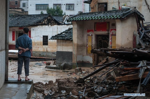  A villager stands in front of houses destroyed by the rainstorm in Guangfu Town of Jiaoling County, Meizhou City, south China's Guangdong Province, May 22, 2013. Meizhou City was hit by a rainstorm on May 19, which killed one people and destroyed 951 houses, leaving 180, 000 people affected in Jiaoling County. (Xinhua/Mao Siqian) 